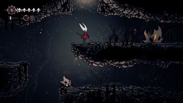 Une créature encore endormi dans Hollow Knight: Silksong avec un grand crâne qui va s'animer quand on s'approche